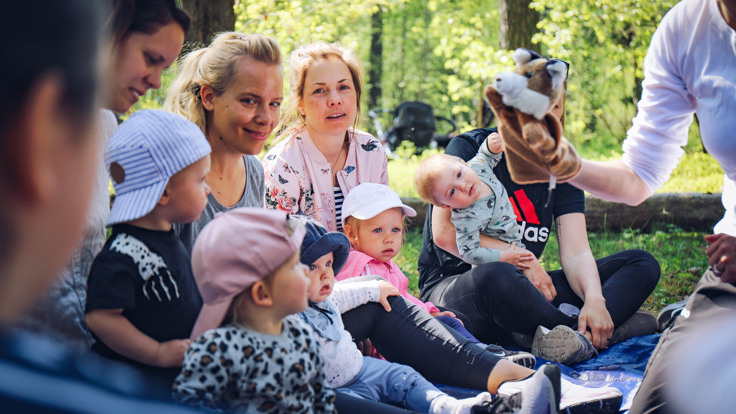 Barnfamiljer på utflykt i skogen.